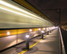 A speeding metro train sets the cool night air ablaze with rushing light