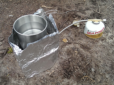 It might not be pretty, but the makeshift tin-foil wind-shield had a cup of water boiling in about four minutes.