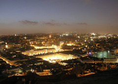 While darkness descends on Lisbon, as viewed from Castle Sao Jorge, the city begins to awake with the sights and sounds of celebrations